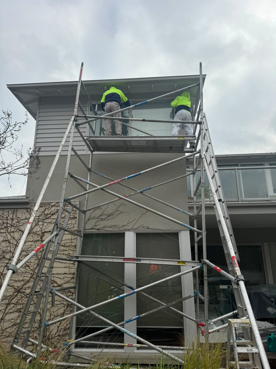 Smooth Painting painter working on a two-storey home from scaffold